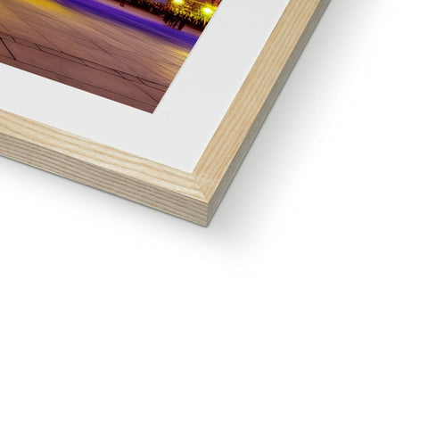 A colorful photo on a white wall is on a large wooden frame.