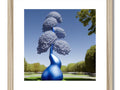 Art print of a blue cloud that is hanging on a tree branch on a wooden display