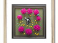 A cute clock frame and a colorful picture in the frame on a wall.