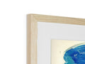 A wooden framed picture of something blue and white on the wall.