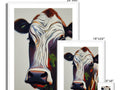 A cow standing in the room looking up at an art print that has the letter �