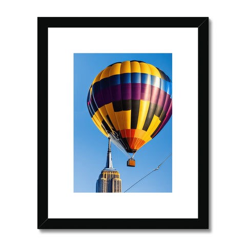 A framed art print of an air balloon sitting on a table with a picture at a