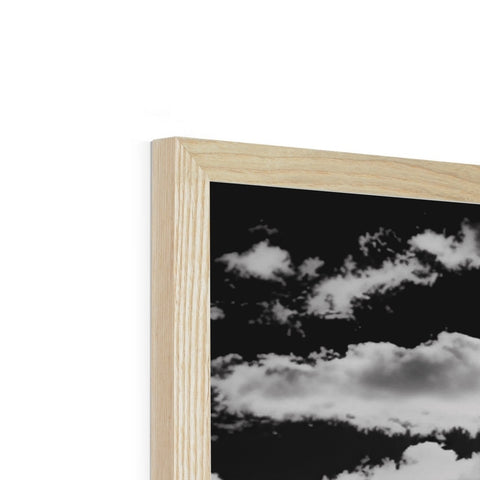 A picture frame with wooden panels on top of a cloudy day and a cloud passing over