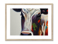 A white cow standing next to brown and black art print that holds horns.