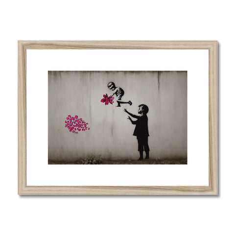 A child pointing flowers from a photo on a wall that is painted on a wooden bulletin