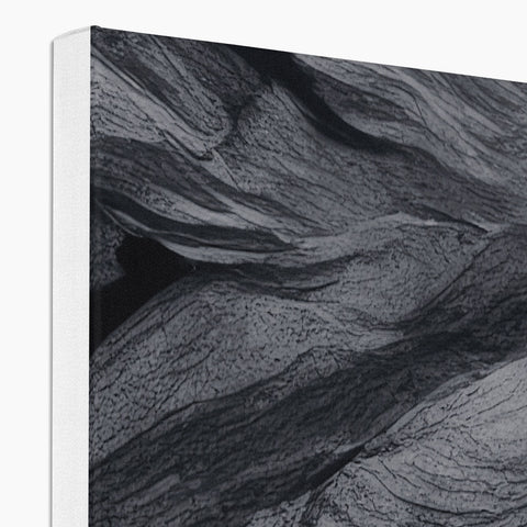 A white soft fold-out book on a white pillow with black paper on it next
