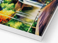 A printed book with two pictures of a landscape on it behind a foldout in a