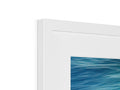 An imac of some white and blue artwork in a frame.