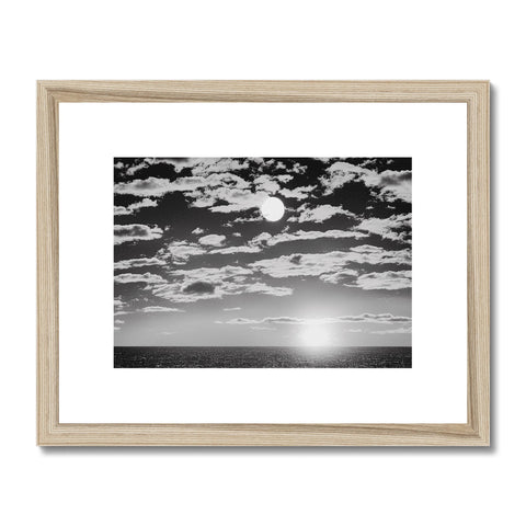A sun setting in the desert on a wooden framed photograph of a horizon.