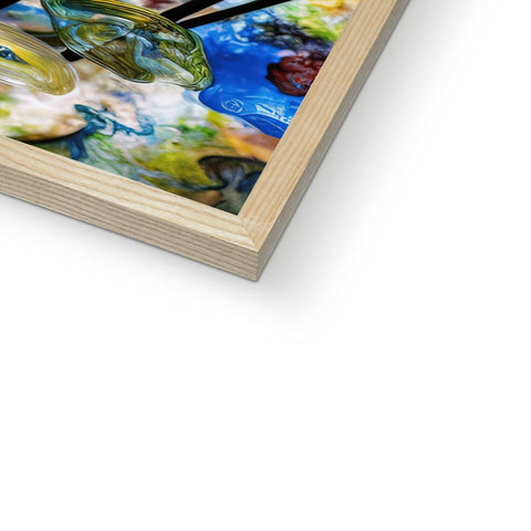 A glass book with an art print on the cover on a piece of wood.