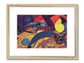 A framed art print that is framed on a wooden desk with colored prints.