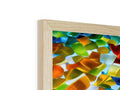 A wooden tabletop with colorful glass that has a wooden piece placed on top of it.