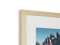 An art print is in a wooden frame in a room.