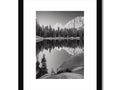 A black and white framed photo of a lake, sitting on top of a black and