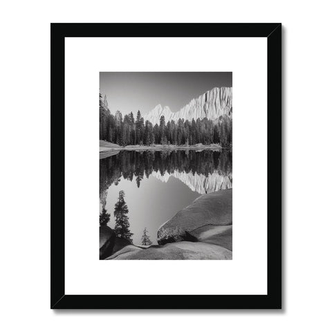 A black and white framed photo of a lake, sitting on top of a black and
