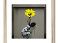 A picture with a large dandelion and a sunflower on a wooden frame.