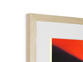 A wooden framed photo that is on top of a picture frame next to a red wall