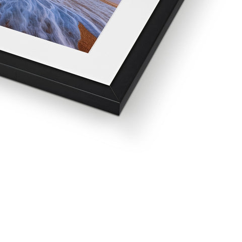 A framed photograph of a picture in a dark place hanging in a white photo frame.