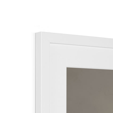 A white picture frame hanging on top of a wall near a mirror.