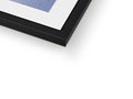 An artwork print in a blue frame is framed on a white table top frame.