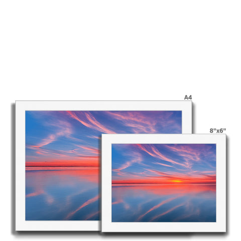 A couple of prints on large colorful print cards sitting on a laptop screen.