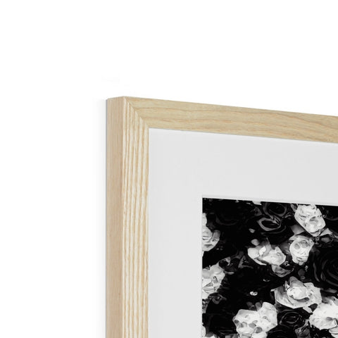A picture frame is covered in many flowers on a piece of wood.
