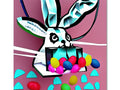A colorful art print in front of a wooden bunny with some candy in the background.