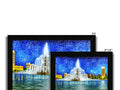 A picture frame with a picture of a city skyline with lights and buildings near a fountain
