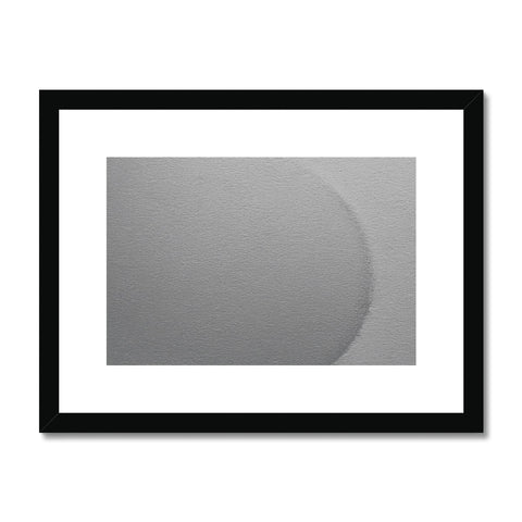 An abstract picture on a metal wall of a white circle and a little piece of cloth