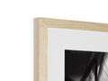 A black and white photo is in a white wood frame.