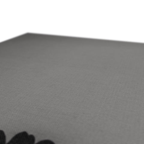 A table with a cloth spread on a black table and white seat cushion.