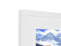A picture frame with a window sill next to an imac with a small picture on