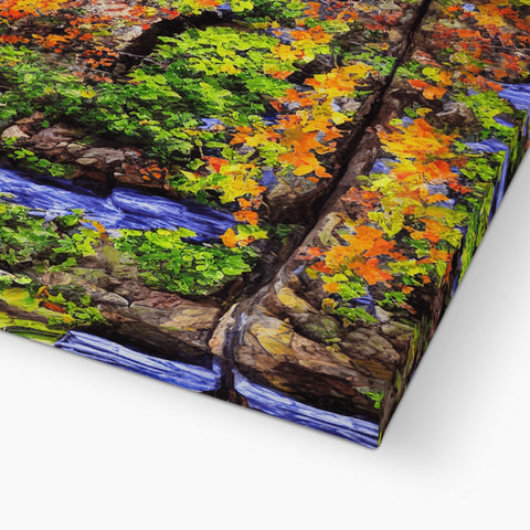 A colorful blanket draped over a tall tree branch on a rocks edge.