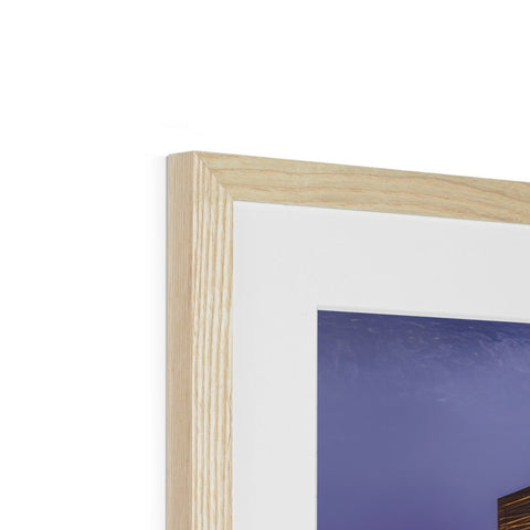 A wooden frame is framed with an image in it on top of a mantel.