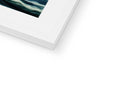 A photograph of an imac hanging in a picture frame next to an ocean.
