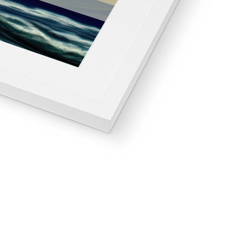 A photograph of an imac hanging in a picture frame next to an ocean.