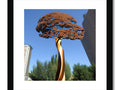Art print sitting atop a sculpture of an ornate tree.