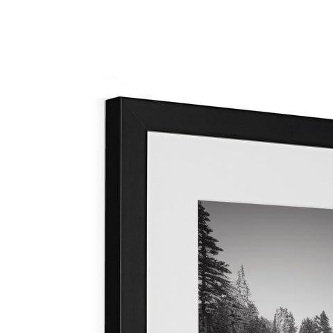 Black and white picture of a picture frame with a mirror behind it mounted with an image