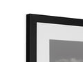 A picture frame in a black frame on a wall and white picture.