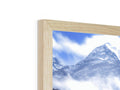 A photograph of a mountain range on a picture frame in a mirror on a window sill