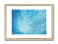 A framed art print on blue paper with green feathers on it.