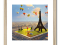 A picture of Paris on a picture frame topped with a tower of an air balloon.