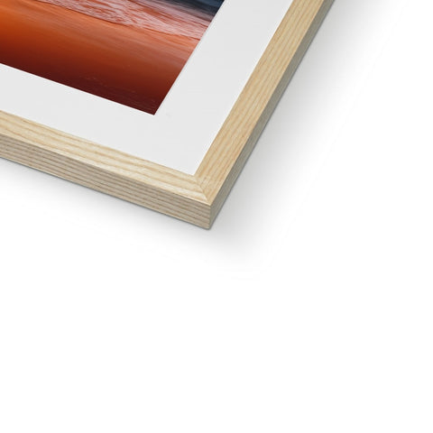 A picture of a photograph in a wooden frame framed in red wood.