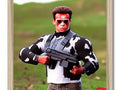 An action figure standing to the side of the picture holding a gun.