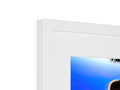 An imac monitor image on a table in a picture frame hanging in a window.