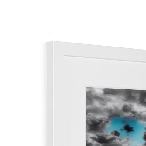 A black and white picture frame with colored art on it displayed with a blue cloud in
