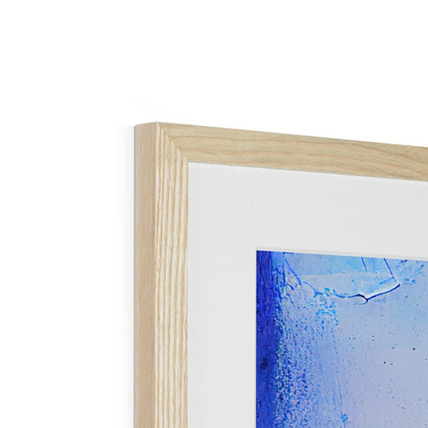 A white photo is in a framed blue and black frame.