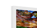 An art print on glass framed piece of art sits on top of a book case.