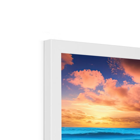 An imac display screen is next to a picture frame hanging on a wall.