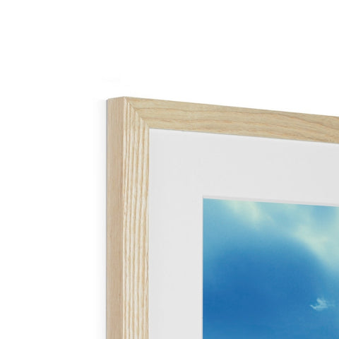 A picture frame on a white wall with wooden frame on top of it.